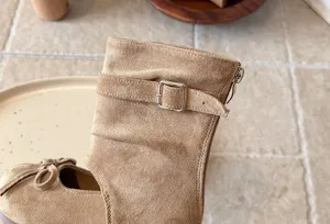 Details of girls khaki suede mid boots, featuring bow decor, buckle strap and side zipper design.