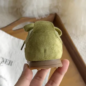 Vue detaillee du talon de sneakers retro en daim vert pour enfants et semelle en gomme.