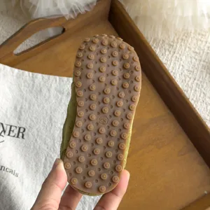 Vue de dessous détaillée de chaussures souples pour enfants avec picots en caoutchouc.