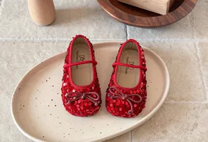 Détail chaussures fille à paillettes rouges, ballerines princesse semelle souple et noeud.