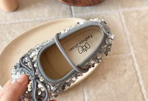 Vue détaillée de ballerines à sequins argentés pour filles, joli nœud brillant, souple.