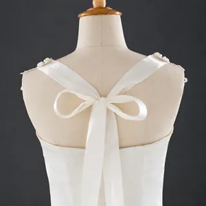Brautkleid Rückansicht Detail mit eleganter Satinschleife und Perlen Schulterträgern.