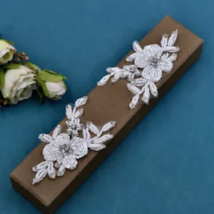 Detailansicht von weißem Perlen-Spitzen-Blumenaufnäher, elegantes DIY-Zubehör für Schuhe.