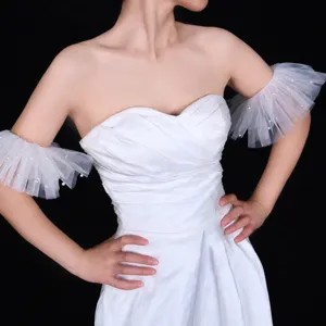 White bridal mesh arm sleeves with pearl decor, detail view for wedding evening gown accessory.