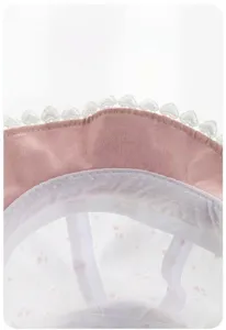 Vista dettagliata della fascia interna parasudore del cappellino da neonato con pizzo.