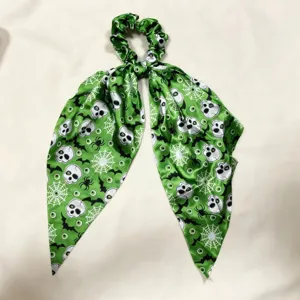 Halloween green skull bat print ribbon scrunchie detail view, soft satin ponytail hair accessory.