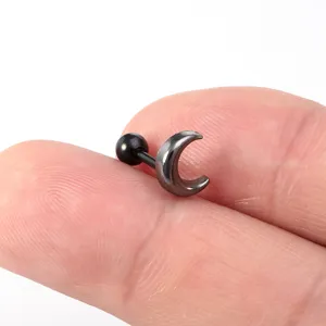 Close-up detail van zwarte maan oorkraakbeen piercing knop met unieke stijl en afwerking.