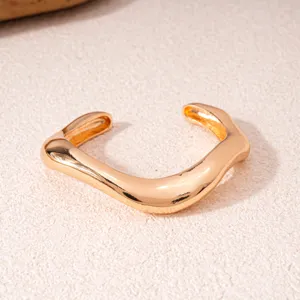 Detailansicht eines stylischen goldenen geometrischen offenen Armbands, ideal für Mode.