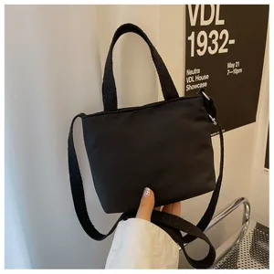 Mini sac cabas en nylon noir, sac bandoulière décontracté montrant les détails et la sangle.