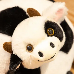 Close-up detail of the cute black and white cow plush toy pillow, soft and fluffy texture.