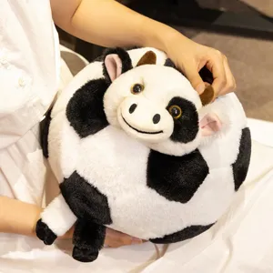Close-up detail of the creative black and white cow football plush pillow toy, soft fabric.