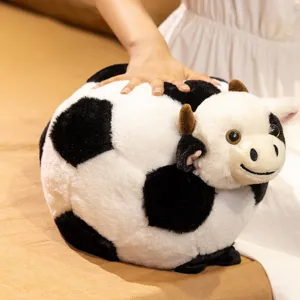Cute cow soccer plush pillow toy, black and white stuffed animal doll for home decor.