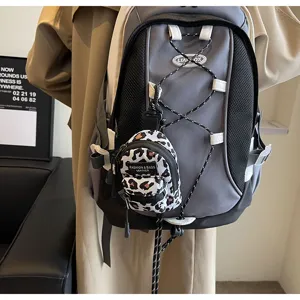 Detailansicht des grauen Stoffrucksacks mit elastischer Kordel und modischer Leo-Mini-Tasche.