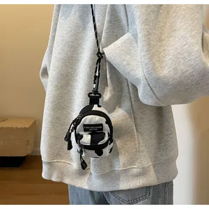 Nahaufnahme einer trendigen Mini-Leinwand-Tasche mit Kuhmuster, Riemen und Reißverschluss.