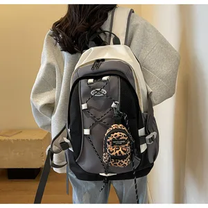 Detailaufnahme des grauen Rucksacks mit praktischen Taschen und süßem Leoparden Mini-Anhänger.