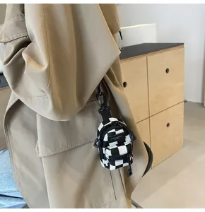 Detailansicht des schwarz-weißen Karierten Mini-Rucksack-Anhängers, trendiges Streetwear-Accessoire.