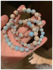 Gros plan détaillé de bracelets de perles en pierre multicolores superposés style.