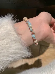 Vue détaillée d'un bracelet de perles porté au poignet avec un accent de manche.