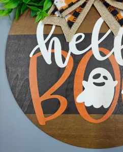 Halloween wooden door sign detail view, cute ghost and BOO text, festive hanging decor piece.