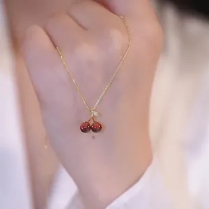 Elegant red cherry pendant necklace with gold chain, perfect dainty jewelry gift for women.