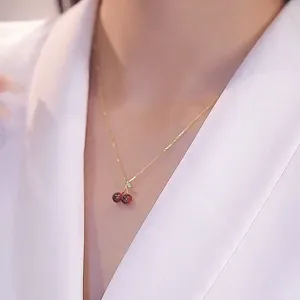 Elegant red garnet cherry pendant necklace for women, delicate gold clavicle chain jewelry.