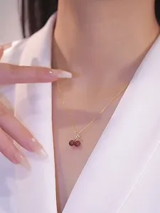 Close-up detail of the elegant red cherry pendant necklace, highlighting delicate craftsmanship.