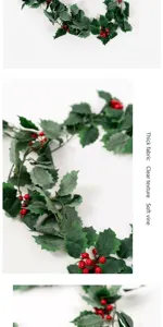 Detail view of artificial Christmas holly vine with realistic green leaves and red berries.