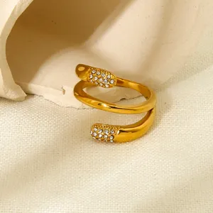 Primo piano dettagliato di un anello avvolgente in acciaio dorato con strass brillanti.