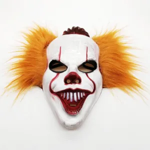 Scary clown mask detail showing white face paint, red makeup, and vibrant orange synthetic hair.