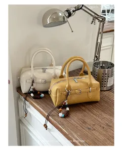 Stylish boston bag with chic belt buckle design and beaded charm, perfect for daily wear.