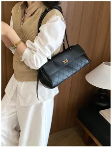 Detailed view of the black quilted leather shoulder bag with chic gold turn-lock hardware.