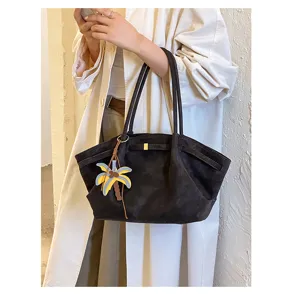 Detail view of retro suede tote bag, stylish shoulder bag with cute palm tree charm.