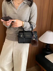 Black top handle crossbody bag for women with woven texture and cute furry ball pendant.