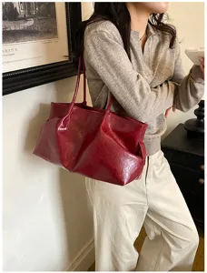 Detail showcase of large dark red patent leather tote bag, retro style casual shoulder handbag.