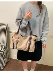 Suede shoulder bag for women with cute bear pendant, trendy underarm bag for daily commute.