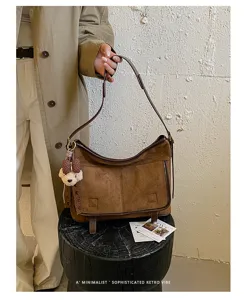 Retro suede shoulder bag for women, chic hobo crossbody bag with cute bear charm and vintage style.