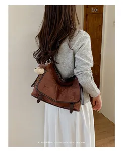 Retro brown suede shoulder bag for women, chic casual crossbody bag with cute bear pendant.