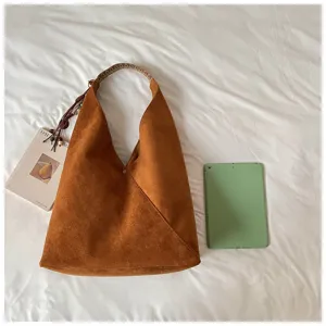 Close-up view of the brown suede hobo shoulder bag highlighting its soft fabric and woven strap.