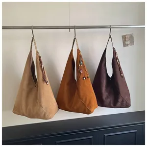 Detailed view of vintage suede slouchy hobo shoulder bag with fringe charm and large capacity.
