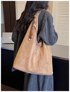 Detail view of large capacity vintage brown suede hobo shoulder dumpling bag with tassel beads.
