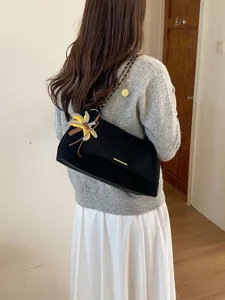 Chic women's black suede underarm shoulder bag featuring elegant chain strap and stylish charm.