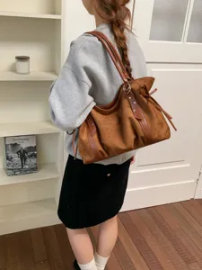 Brown suede shoulder bag for women, stylish underarm hobo bag with leather straps and chic side ties.