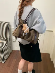 Casual brown canvas shoulder bag for women with dark brown leather trim and cute bear pendant.