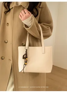 Primo piano dettagliato di borsa tote minimalista con ciondolo chic ed elegante.