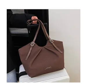 Borsa a tracolla in pelle PU marrone vista di dettaglio con fibbie metalliche.