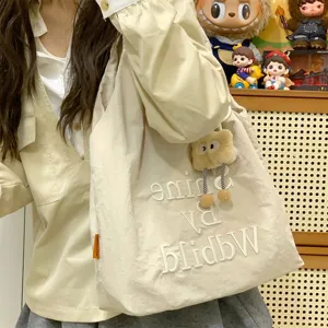 Casual beige canvas tote bag with letter embroidery and plush pendant, daily shoulder bag.