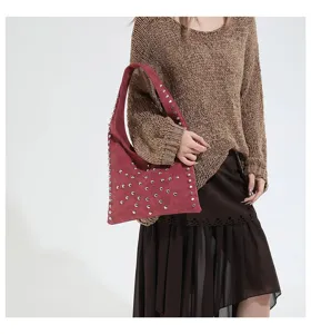 Detailed shot of the stylish studded hobo shoulder bag with soft suede material and metal rivets.