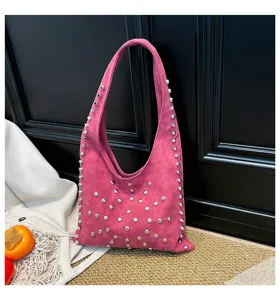 Pink suede shoulder bag featuring edgy silver metal studs, stylish hobo underarm design for women.