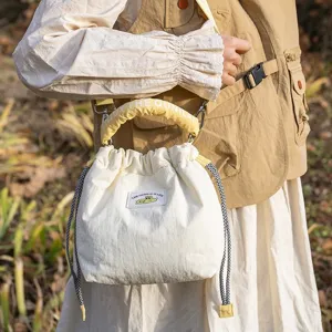 Detail view of Japanese vintage quilted camera bag with drawstring closure and yellow handle.