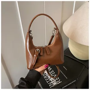 Detail view of the stylish brown crescent shoulder bag, showing premium leather and hardware.